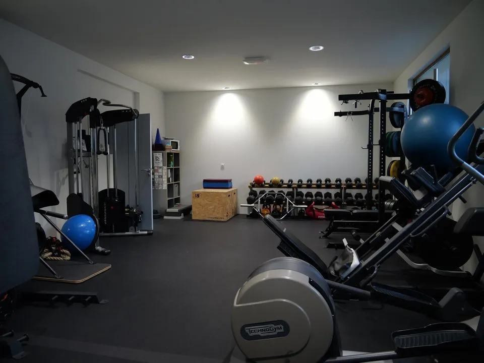Salle de préparation physique équipée de racks, haltères et cardio